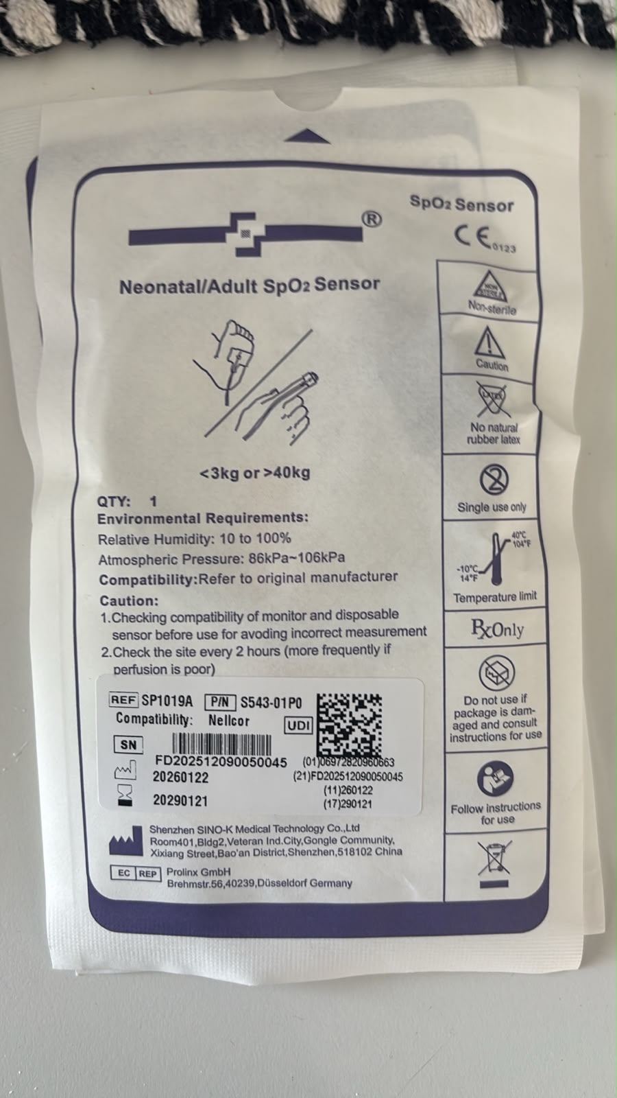 Etiqueta real del empaque individual SINO-K SP1019A, P/N S543-01P0, compatible con Nellcor; la venta corresponde a caja con 24 sensores