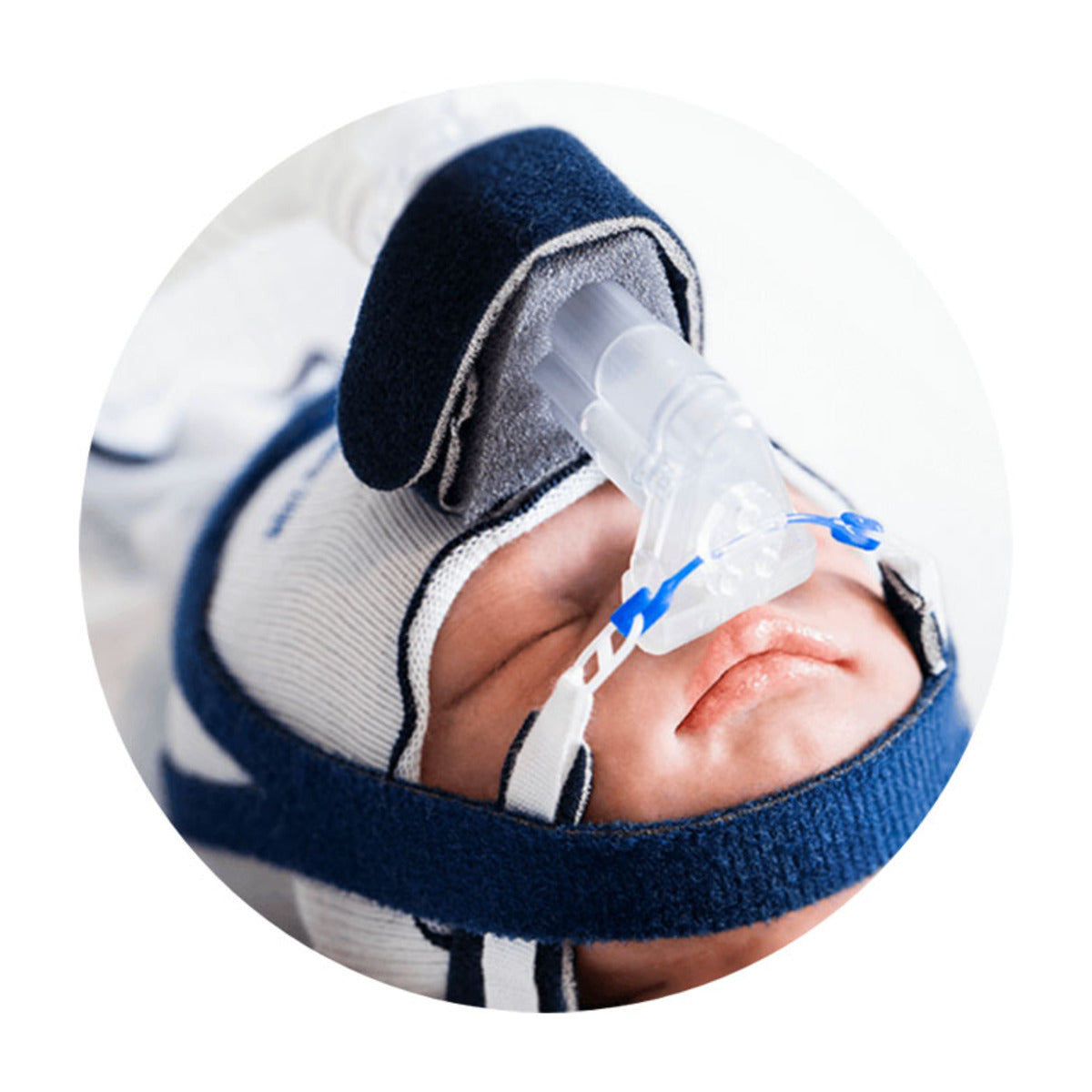 Recién nacido con interfaz FlexiTrunk Fisher & Paykel, mascarilla nasal y gorro, foto oficial