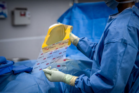 3M Ioban 2, campo de incisión antimicrobiano con liner impreso, en manos enguantadas en quirófano
