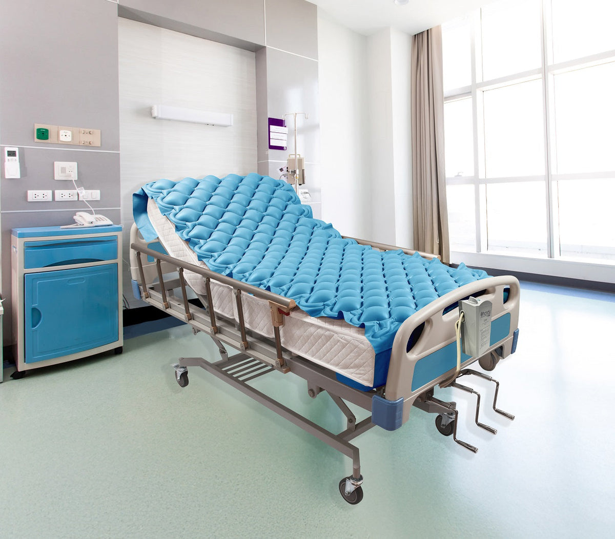 Colchón de burbujas Handy CC01 sobre una cama de hospital, con la bomba en la piecera; la cama no se incluye